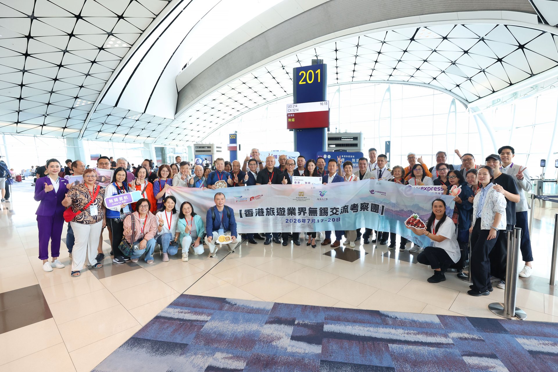 The HK Express management team takes photos with passengers and distributes souvenirs at Hong Kong International Airport to celebrate the inaugural flight of the Hong Kong–Wuxi route. 
